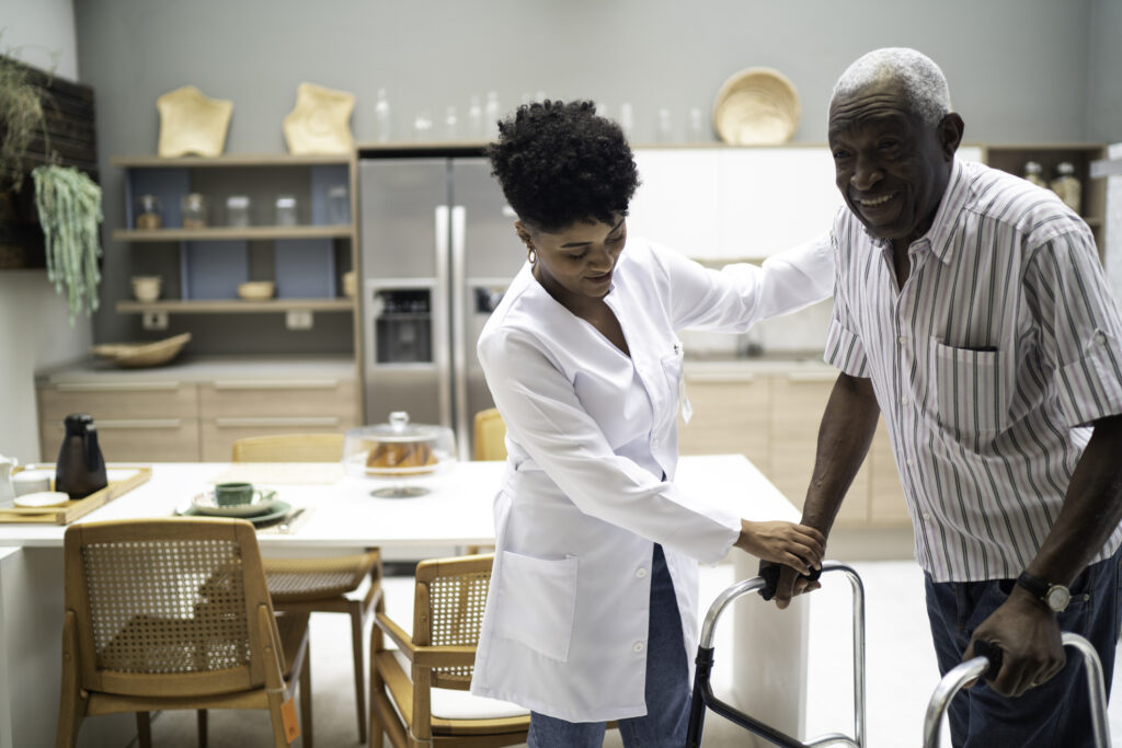 Caretaker assisting senior man with walker